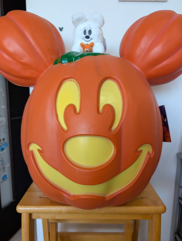 ミッキーの形をしたハロウィンのかぼちゃ。上にはゴースト姿のミッキーのぬいぐるみがのっている